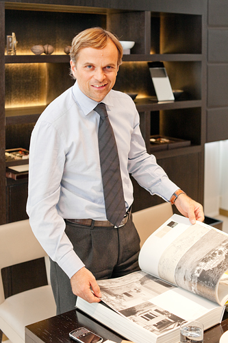 Jean-Frédéric Dufour leafing through a book on Le Corbusier (the page spread showing Georges Favre-Jacot's mansion)